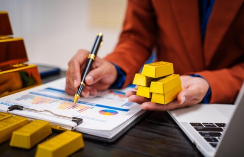 An Asian businesswoman sitting at her desk in office,analyzing gold bullion prices,market trends